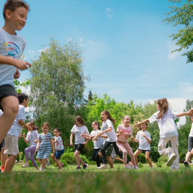 A group of children happily playing in a sunny park, enjoying outdoor activities and fun.